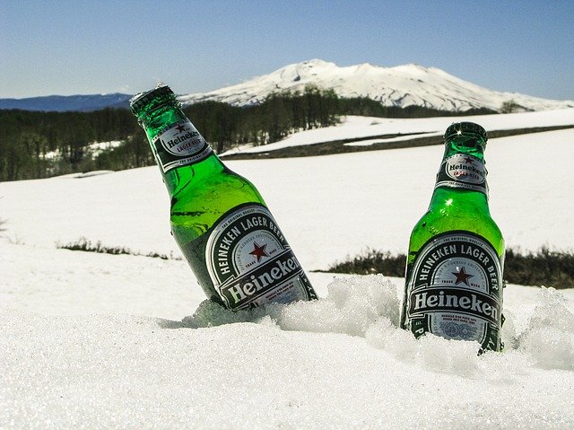 two heinekens immersed in snow