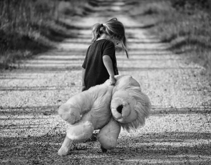 little girl dragging old cloth lion