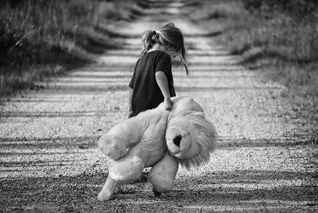 little girl dragging old cloth lion